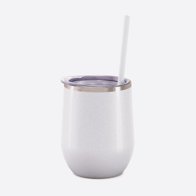 May include: A white glittery stainless steel tumbler with a rounded shape, featuring a clear plastic lid and a straight white straw inserted through the top. The exterior has a subtle sparkling finish and a metallic rim around the opening.