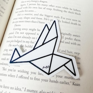 May include: A white sticker featuring a black-outlined geometric origami bird design. The sticker has a clean, angular shape with sharp lines forming the wings and body of the bird. The word nee is printed in small black script on the lower section.