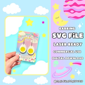 May include: A pair of white and yellow egg-shaped earrings on a card with the text "Smiley Moon Studio". The card is in front of a hand holding the earrings. The text "EARRING SVG FILE LASER READY COMMERCIAL USE DIGITAL DOWNLOAD" is on the right side of the image. The background is a light blue color with white clouds and yellow stars.