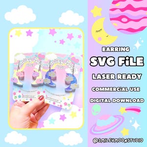 May include: A pair of pastel-colored crescent moon earrings with clouds and glitter accents. The earrings are on a white card with the text "Smiley Moon Studio" and "EARRING SVG FILE LASER READY COMMERCIAL USE DIGITAL DOWNLOAD @SMILEYMOONSTUDIO".