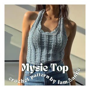 Può includere: Un top halter in crochet blu chiaro con scollo a balze. Il top è indossato da una persona con capelli lunghi e scuri e abbinato a jeans blu. Il testo "Mysie Top crochet pattern by lam.kanka" è visualizzato sotto il top.