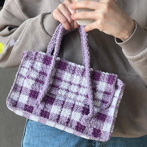 Może przedstawiać: Torebka typu tote wykonana na szydełku w kratę w kolorze fioletowym i białym z jednym uchwytem.