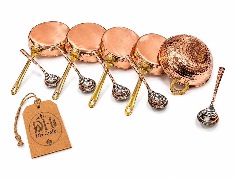 May include: A set of four small copper pans with brass handles, each paired with a matching metal spoon. A larger hammered copper bowl with a brass handle and a separate spoon are included. A brown paper tag features the text DH Crafts.