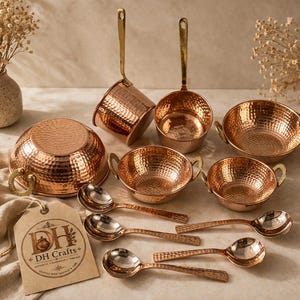 May include: A selection of copper kitchen utensils, featuring bowls, ladles, and spoons, all with a hammered finish and brass handles. The set includes a large bowl, several smaller bowls, and serving spoons. A tag with "DH Crafts" is present.
