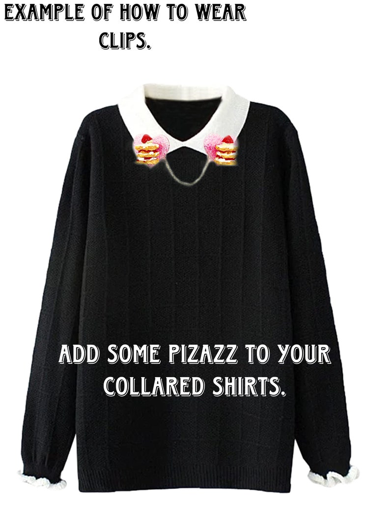 May include: A black sweater with a white collar and a chain with two strawberry and cream pancake charms attached to the collar. The text "EXAMPLE OF HOW TO WEAR CLIPS." is at the top of the image. The text "ADD SOME PIZAZZ TO YOUR COLLARED SHIRTS." is at the bottom of the image.