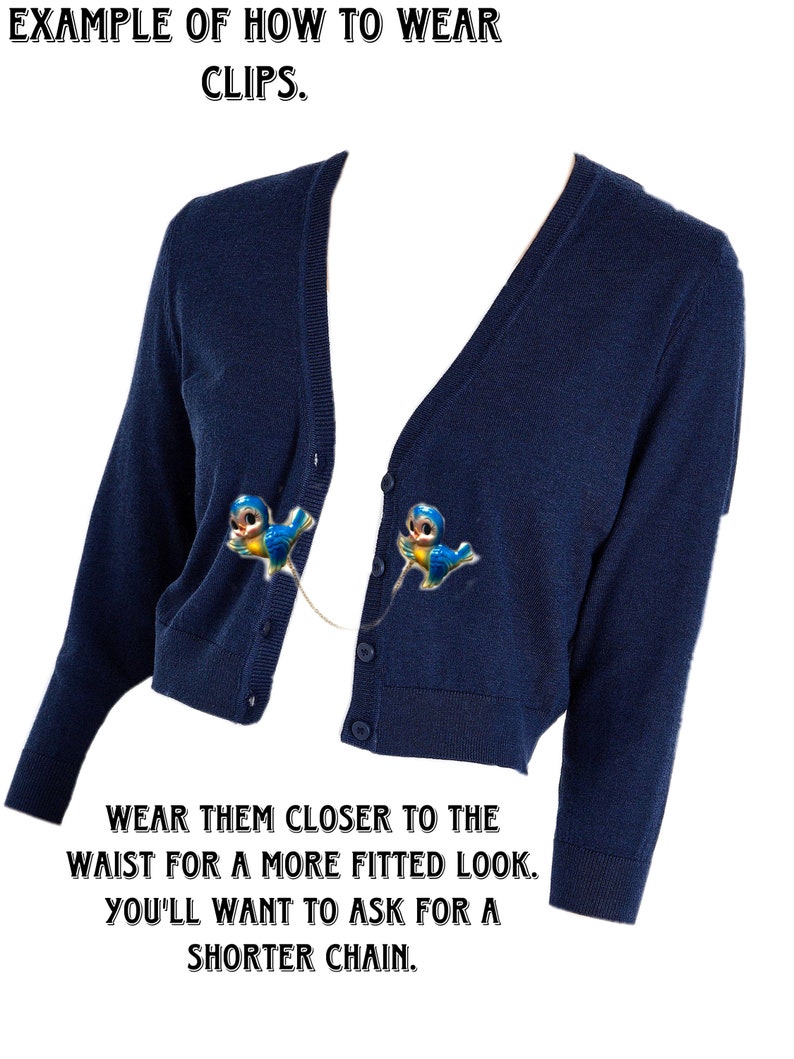May include: A navy blue cardigan with two blue bird clips attached to the front. The text "EXAMPLE OF HOW TO WEAR CLIPS." is at the top of the image. The text "WEAR THEM CLOSER TO THE WAIST FOR A MORE FITTED LOOK. YOU'LL WANT TO ASK FOR A SHORTER CHAIN." is at the bottom of the image.