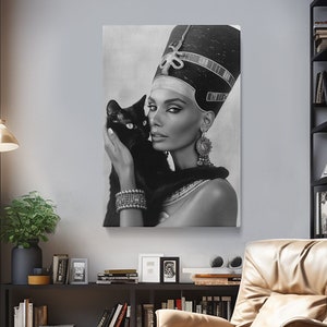 May include: Black and white portrait of a woman wearing a crown and holding a black cat. The woman is looking at the camera and the cat is looking at the woman. The background is a light gray.