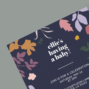 以下が含まれることがあります： 花柄のネイビーブルーのベビーシャワー招待状。テキストには「ellie's having a baby!」とイベントの日時と場所が記載されています。