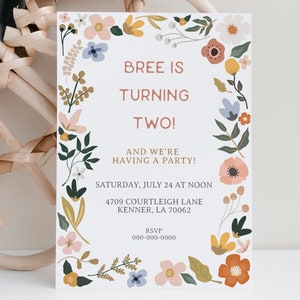 May include: A white invitation card with a floral border. The text reads "Bree is turning two! And we're having a party! Saturday, July 24 at noon 4709 Courtleigh Lane Kenner, LA 70062 RSVP 000-000-0000"