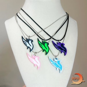 May include: Five necklaces with different colored pendants. Each pendant is a stylized bird with wings spread. The colors are white, green, purple, pink, and blue.
