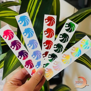May include: Five sheets of stickers with a lion head design. The stickers are in different colors: red, blue, green, pink, and iridescent.