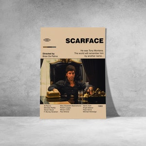 May include: A tan poster featuring the movie "Scarface" with the film's title in bold black letters. The poster includes a still image of Tony Montana, the film's main character. The poster also lists the director, cast, and the year 1983.