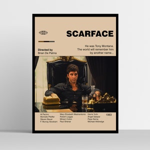 May include: A framed poster for the film "Scarface" featuring Al Pacino. The poster has a tan background with the film title and credits. The image shows Pacino as Tony Montana, seated in a chair. The poster includes the director's name and the year 1983.