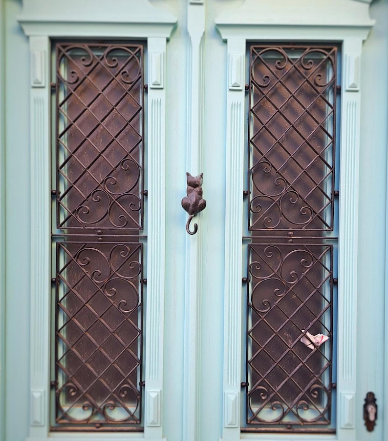 Antique brass cat-shaped door knocker on door