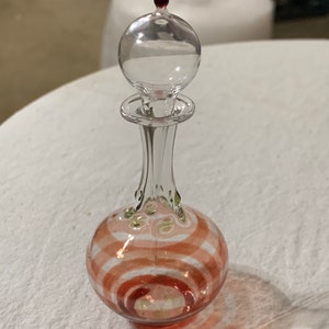small glass stoppered 'perfume' bottle with a colored stripe and colored collar of dots on a clear background. hollow glass stopper