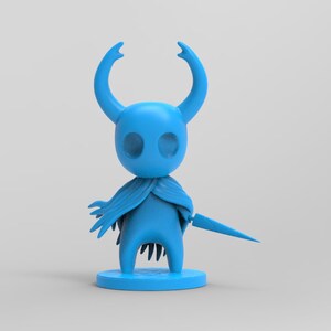 Può includere: Una statuetta di plastica blu di un cavaliere con una lunga spada appuntita. Il cavaliere ha una grande testa rotonda con due grandi occhi e un lungo naso appuntito. Il cavaliere indossa un lungo mantello svolazzante.