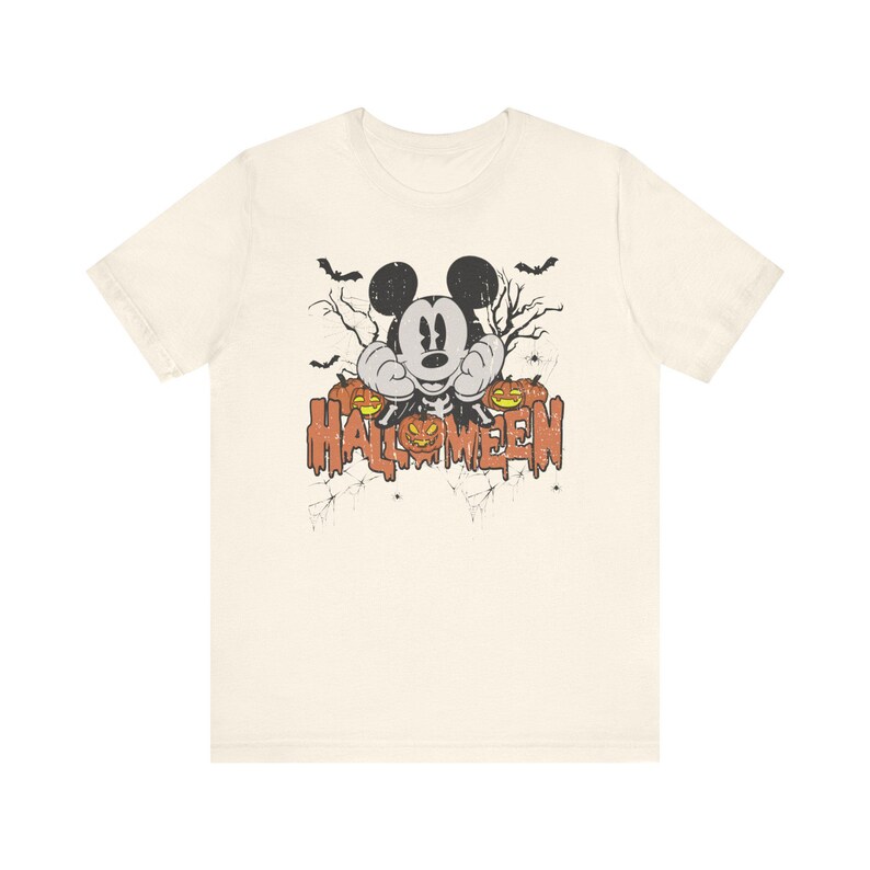 May include: A white t-shirt with a vintage-style graphic of Mickey Mouse dressed as a skeleton with pumpkins and the text "HALLOWEEN".
