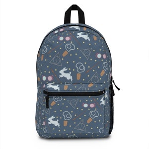 May include: A blue backpack with a white rabbit, glasses, wand, and the Deathly Hallows symbol repeated in a pattern.