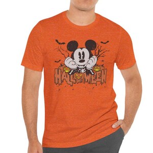May include: Orange t-shirt with a distressed graphic of Mickey Mouse dressed as a skeleton holding pumpkins and the text "HALLOWEEN".