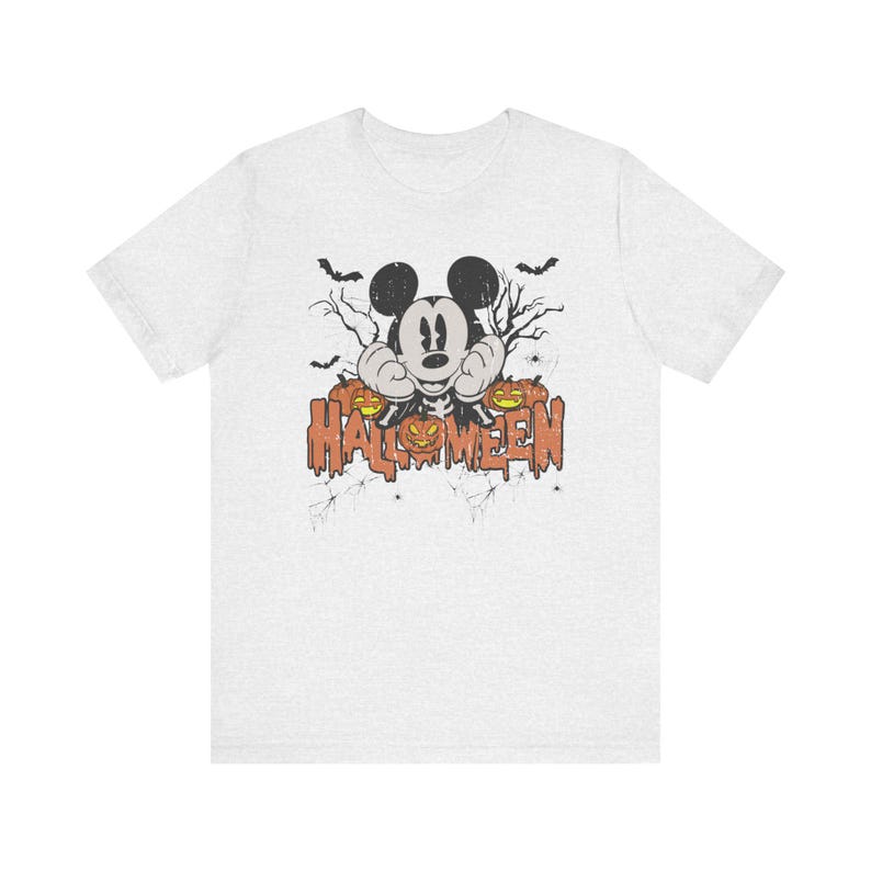 May include: A heather grey t-shirt with a vintage-style graphic of Mickey Mouse dressed as a Halloween character. The graphic includes Mickey Mouse with a jack-o-lantern and the text "HALLOWEEN".