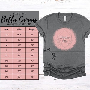 May include: Size chart for a unisex Bella Canvas t-shirt in grey with a white and pink design that says "Wonder Lane Shop". The chart shows sizes XS to 5XL with corresponding width and length measurements in inches.