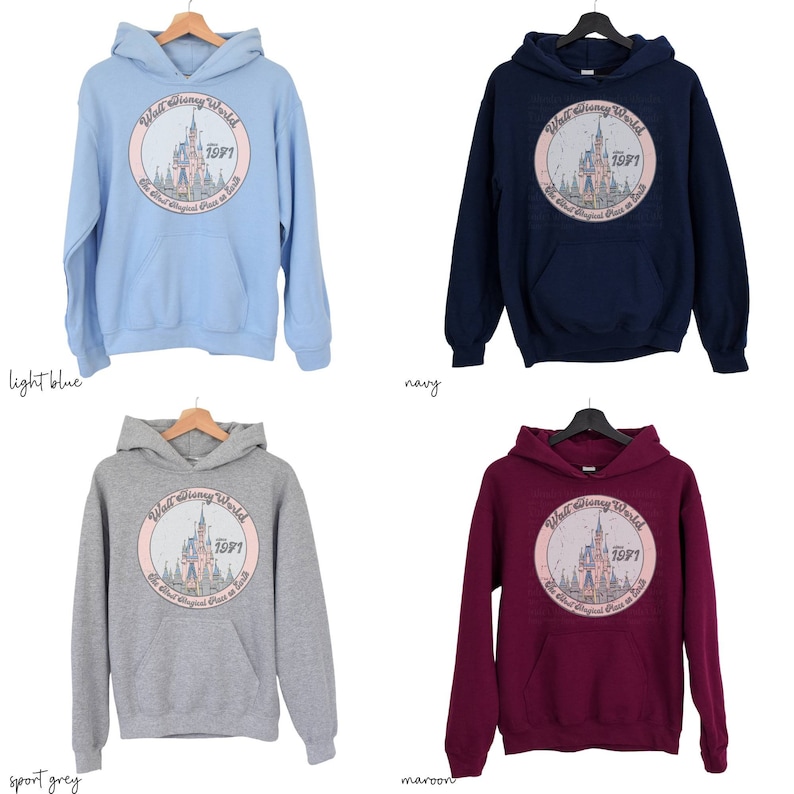 Puede incluir: Cuatro sudaderas con capucha de diferentes colores con un gr&aacute;fico del castillo de Cenicienta y el texto "Walt Disney World 1971 The Most Magical Place on Earth" en un c&iacute;rculo. Los colores son azul claro, azul marino, gris deportivo y granate.