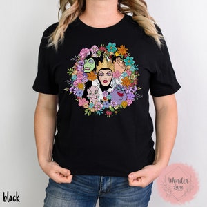 May include: Black t-shirt with a colorful floral design featuring the faces of Disney villains, including Maleficent, Cruella de Vil, and Ursula.