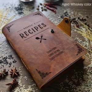 Könnte beinhalten: Ein braunes Leder-Rezeptbuch mit dem Text "ANDREA'S RECIPES" und "GOOD FOOD. GOOD DRINK. GOOD COMPANY." auf dem Einband.