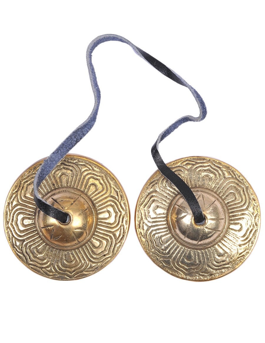 Tingsha Cymbals Tibetan Buddhist Lucky Symbol Embossed Meditation Yoga Bell  Chimes on black contrasting background. Tibetan bells for singing mantra.  Mantra bowls with leather ribbon. Stock Photo