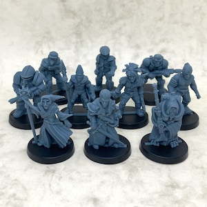Könnte beinhalten: Eine Sammlung von zehn grauen Miniaturfiguren verschiedener Fantasy-Charaktere, darunter Krieger und ein Zauberer. Jede Figur ist auf einem schwarzen, kreisförmigen Sockel befestigt. Geeignet für Tabletop-Spiele oder Ausstellungen.