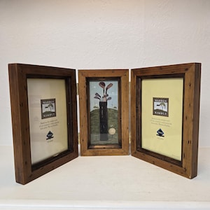 May include: A wooden tri-fold picture frame with three separate images. The center image shows a golf bag with golf clubs and a golf ball. The left and right images feature a white background with black text that reads "Warren Kimble" and a small image of a house.