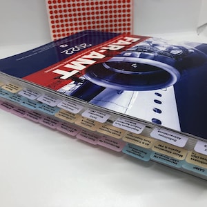 May include: A blue and red book titled "FAR-AMT 2022" with a picture of an aircraft engine on the cover. The book has several colour-coded tabs along the spine, each with a different section title.