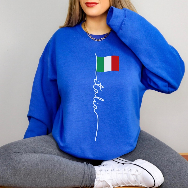 May include: A royal blue sweatshirt with a white graphic of the Italian flag and the word "italia" written in cursive.