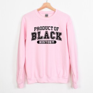 May include: Pink sweatshirt with black text that reads "Product of Black History".