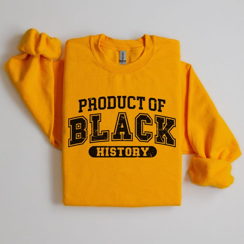 May include: A yellow sweatshirt with the text "PRODUCT OF BLACK HISTORY" in black lettering.