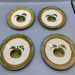 Puede incluir: Juego de cuatro platos de postre de cerámica verde y marrón con un diseño de manzana pintado a mano.