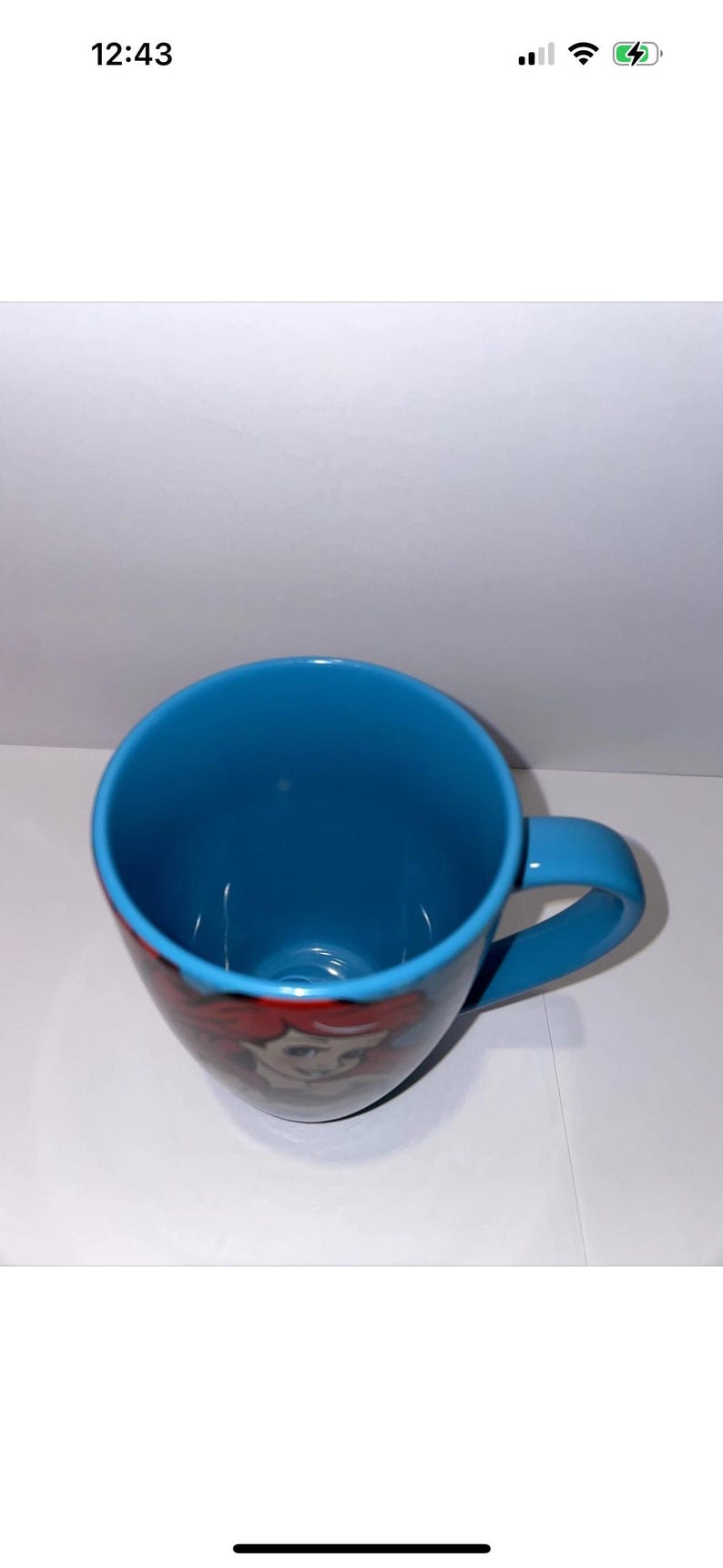 May include: A blue ceramic mug with a matching handle. The mug features a colourful illustration of a character from a popular animated film. The interior of the mug is also blue.