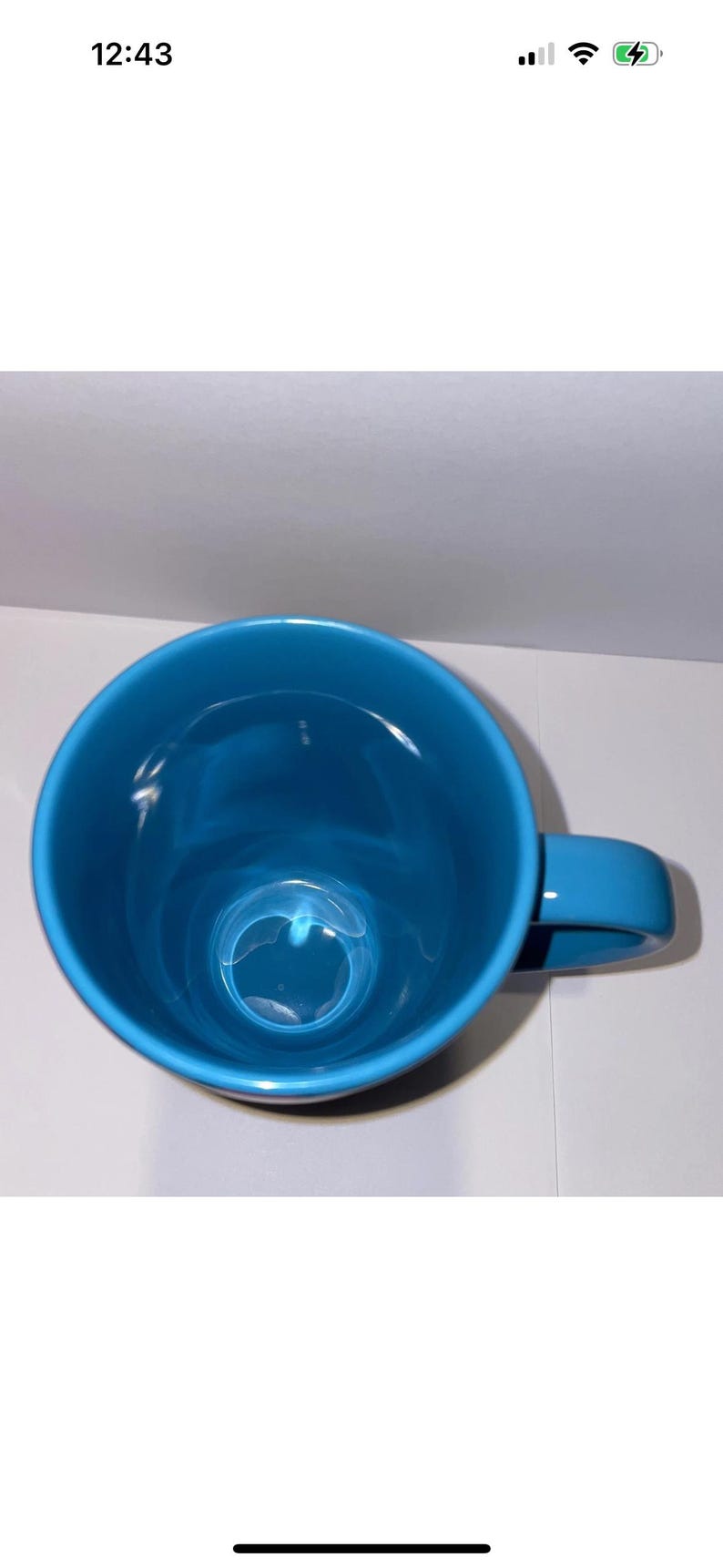 May include: A bright teal ceramic mug with a rounded body and a matching handle. The mug is empty and sits on a white surface. The mug is a solid colour with a glossy finish.