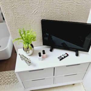Nowoczesny telewizor z płaskim ekranem do sypialni/kuchni na nowoczesnym stojaku z pilotem, domek dla lalek, telewizor miniaturowy