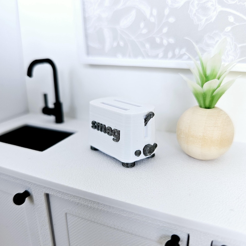 May include: White Smeg toaster with black accents on a white countertop. The toaster has two slots and a lever on the side.