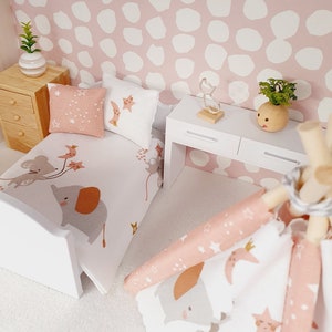 Puede incluir: Un dormitorio de casa de muñecas con una cama blanca, ropa de cama rosa y blanca y una tienda de campaña tipi rosa y blanca. La habitación tiene un papel tapiz de lunares rosa y blanco y una cómoda blanca con dos cajones.