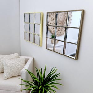 May include: Two square mirrors with a grid pattern. The mirror on the left has a light yellow frame, and the mirror on the right has a brown frame.