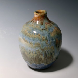 Botella pequeña de arena y mar