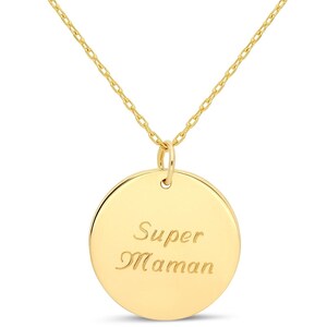 Puede incluir: Un collar de oro con un colgante redondo que dice "Super Maman" en cursiva.