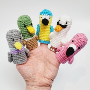 May include: Five colorful finger puppets, each with a different animal design. The puppets are made of crocheted yarn and feature a variety of colors, including green, blue, white, pink, and gray.