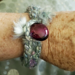 Multicolored woven bracelet with large purple glass bead closure and stone and glass beads