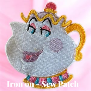 May include: Embroidered patch featuring a cartoon teapot character with a smiling face, blue eyes, and pink accents. The patch has a gold handle and trim, with the text "Iron on - Sew Patch" at the bottom. The patch is white with a pink background.