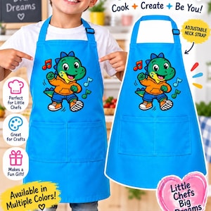 May include: A bright blue apron featuring a cartoon dinosaur wearing an orange hoodie and blue trousers. The apron includes two front pockets and an adjustable neck strap. The text Kids Apron, Cook, Create, Be You, and Little Chefs Big Dreams is visible.