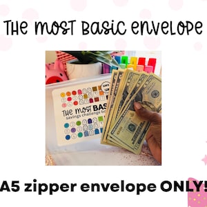 May include: An A5 zipper envelope with the text "THE MOST BASIC envelope" and "savings challenge box". The image shows a hand holding several twenty-dollar bills. The envelope has a colorful savings chart.