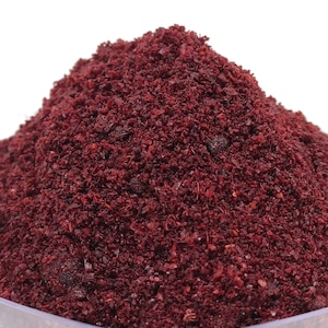 Puede incluir: Primer plano de un montón de zumaque seco y molido, una especia de color rojo púrpura que se utiliza en la cocina de Oriente Medio y el Mediterráneo.
